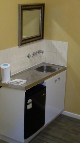 a bathroom with a sink and a mirror at Central Private Hotel in Sydney