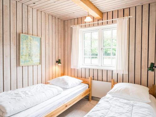 two beds in a room with a window at 4 person holiday home in Nørre Nebel in Nørre Nebel