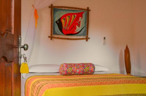 - une chambre avec un lit et une peinture murale dans l'établissement Pousada Vila Caju, à São Miguel do Gostoso