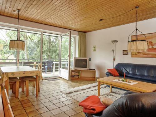 ein Wohnzimmer mit einem Sofa und einem Tisch in der Unterkunft Snug Apartment in St Andreasberg in Harz in Sankt Andreasberg