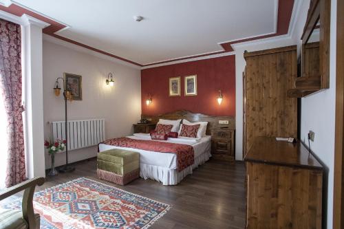 a bedroom with a large bed with red walls at Garden House Hotel - Special Class in Istanbul