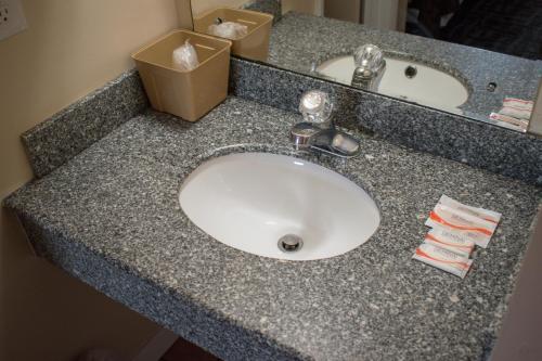 a bathroom counter with a sink and a box on it at Inn of Lenoir Motor Lodge in Lenoir City