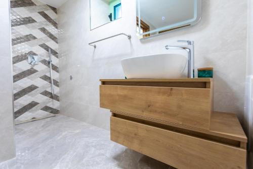łazienka z umywalką i lustrem w obiekcie Holiday house DREAM w mieście Milohnići