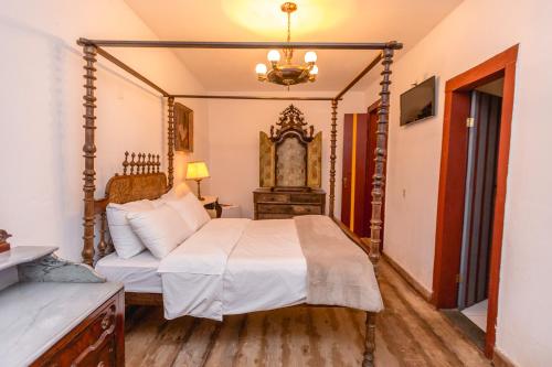 a bedroom with a bed and a dresser at Vila Relicário in Ouro Preto