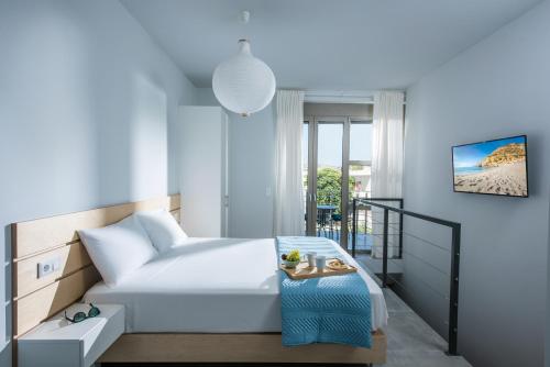 a bedroom with a white bed and a table at royal nest in Matala