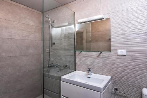 a bathroom with a sink and a glass shower at royal nest in Matala