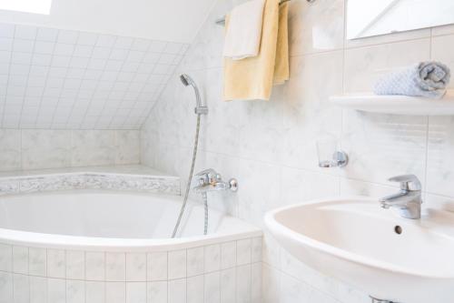 een witte badkamer met een bad en een wastafel bij Gasthof Schützenwirt in Steinach am Brenner