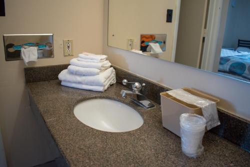 a bathroom counter with a sink with towels on it at Kings Inn in Lenoir City