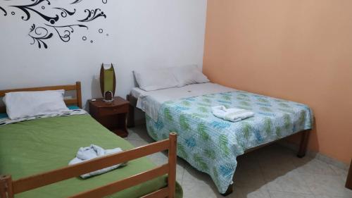 1 dormitorio con 2 camas y toallas. en Hotel Dorado Real, en Fusagasuga