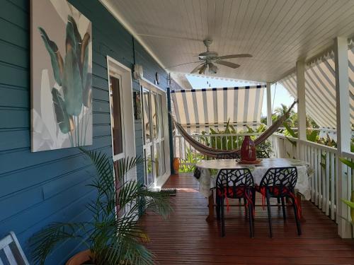a patio with a table and chairs on a porch at Les Gites Capra - Papaye in Bouillante