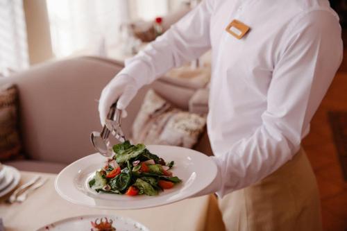 a man cutting a plate of food with a fork and knife at Medeu in Kostanay