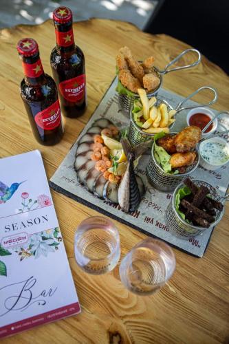 a table with a tray of food and two bottles of beer at Medeu in Kostanay