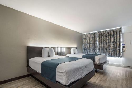 a hotel room with two beds and a window at Motel 6 Groves, Tx in Groves