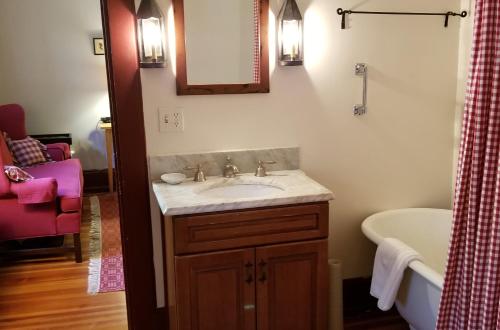 a bathroom with a sink and a bath tub at Timbercliffe Cottage Inn in Camden