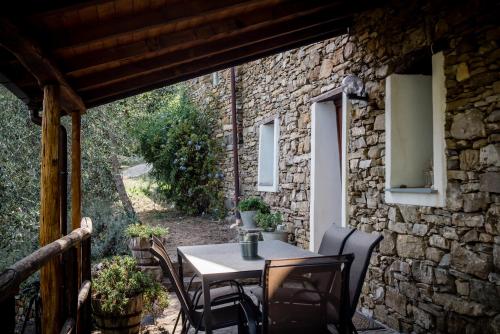 una mesa y sillas en un patio con una pared de piedra en Nostro Rifugio, en Apricale