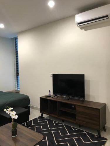 sala de estar con TV de pantalla plana en la pared en Cozy Studio at Kozi Square en Kuching
