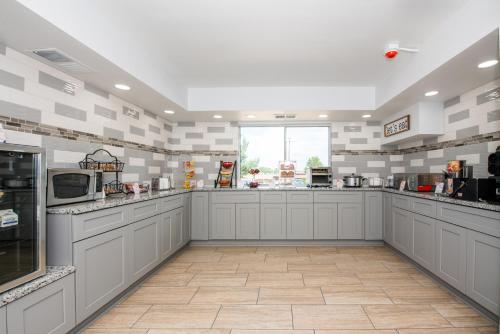 Hotel Pommier Indianola في Indianola: مطبخ كبير مع دواليب بيضاء ونافذة