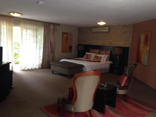 een hotelkamer met een bed en een stoel bij The Waterfront Country Lodge in Vaalview