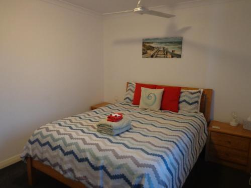 a bedroom with a bed with a blue and white comforter at The Beach Villa Bunbury in Bunbury