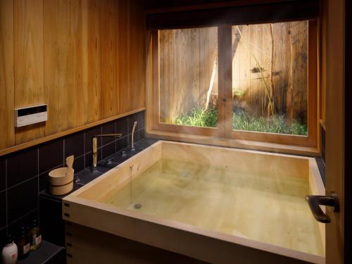 y baño con bañera y ventana. en Tsumugi Nishinotoinhanayacho, en Kioto