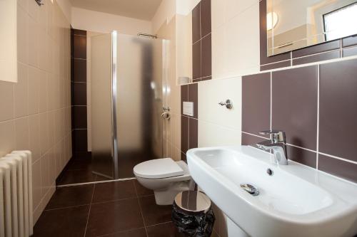 y baño con lavabo, aseo y ducha. en Hotel Stella, en Plzeň