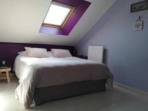a bedroom with a large bed with a purple ceiling at Grand duplex tout confort, à 2km de la Baie de Cancale - Mt St Michel in La Fresnais