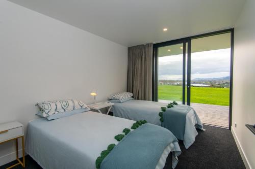 a hotel room with two beds and a large window at Karapiro BlackBox in Karapiro
