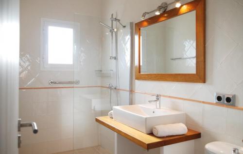 a bathroom with a sink and a mirror and a shower at Casa Can Relax in Es Pujols