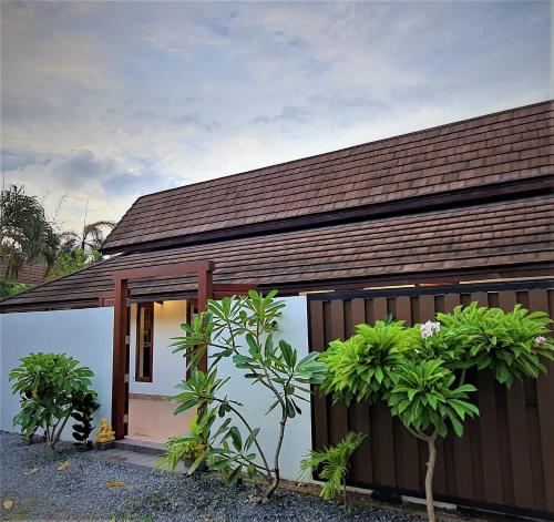 una pequeña casa con techo marrón en Orange palm pool villa, en Koh Samui 