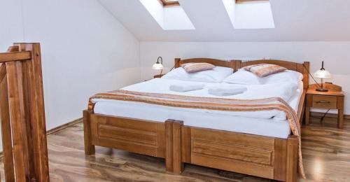 a bedroom with a bed with white sheets and pillows at Kolštejn wellness centrum in Branná