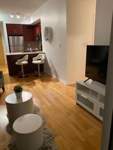 a living room with two stools and a flat screen tv at Toronto CN Tower Maple Leaf Square Luxurious 2 Bedroom Condo in Toronto