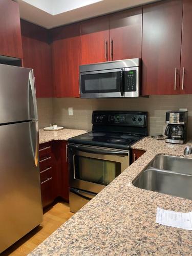 a kitchen with a stainless steel refrigerator and a sink at Toronto CN Tower Maple Leaf Square Luxurious 2 Bedroom Condo in Toronto