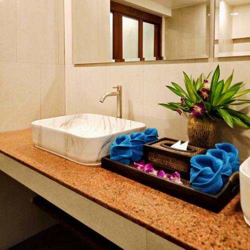 a bathroom counter with a sink and flowers on it at Orange palm pool villa in Chaweng