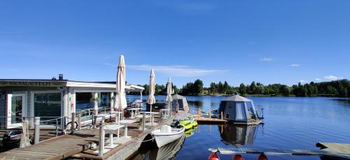 a dock with boats and umbrellas on the water at Koivuranta Igloos in Oulu