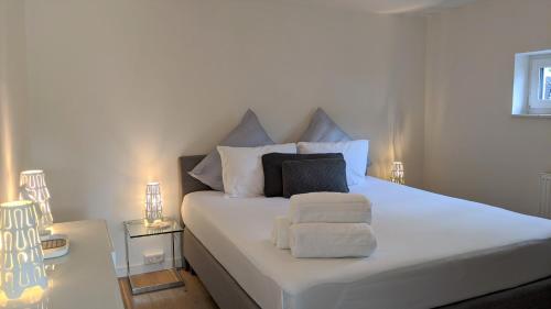 a bedroom with a white bed with towels on it at Klosterberghaus - Kontaktloser Check-in in Elchingen