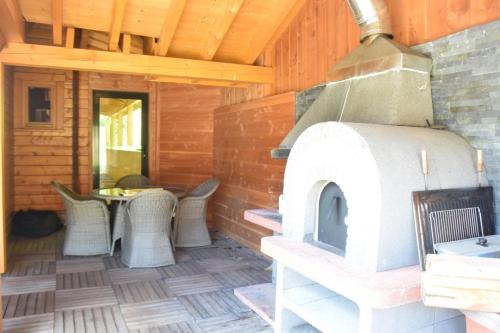 una cabaña con patio y horno al aire libre. en Chalet le Bruleux, en La Bresse