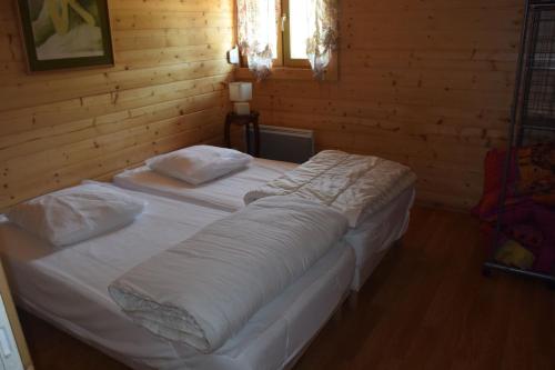 1 dormitorio con 2 camas en una habitación de madera en Chalet le Bruleux, en La Bresse