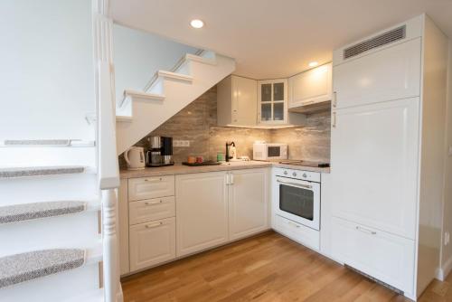a kitchen with white cabinets and a staircase at Live with a fantastic view in the city center in Prague