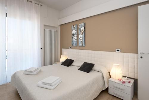 um quarto com uma cama branca e toalhas em Rosella Apartment em Verona