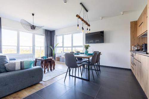 a kitchen and living room with a table and chairs at Symphony Baltica Towers Apartamenty in Gdańsk