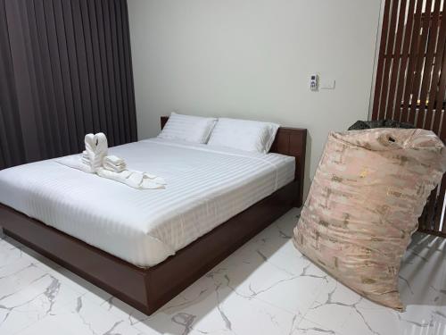 a bed with white sheets and shoes on top of it at Suan Son Villa Koh Sa Nher สวนสนธิ์วิลล่า เกาะเสนอ SHA in Surat Thani