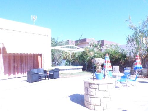 a patio with chairs and umbrellas and a table at Katerinas Place in Analipsi