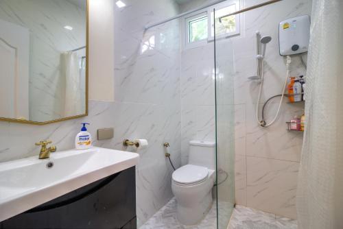 een badkamer met een douche, een toilet en een wastafel bij Rattana House Homestay in Koh Samui 