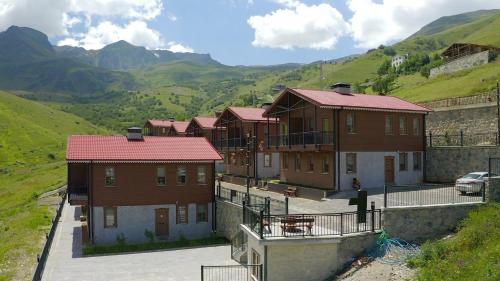 um grupo de casas com montanhas ao fundo em Kaya Life Resort em Uzungol