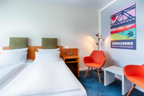 a hotel room with a bed and two chairs at Hotel Carolinenhof in Berlin