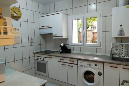 cocina con lavadora y ventana en LA CASA DE LOS ABUELOS en Las Navas del Marqués