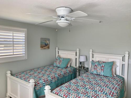 1 dormitorio con 2 camas y ventilador de techo en Island House Beach Resort 7 en Siesta Key