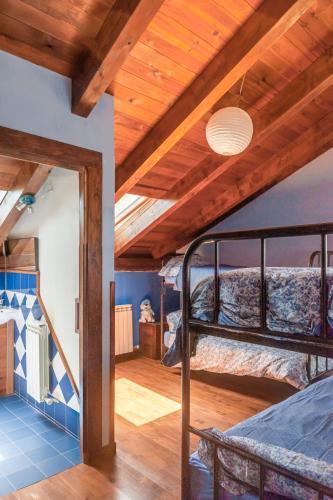 a bedroom with two bunk beds and a wooden ceiling at Albergue A'Noguera in Castiello de Jaca