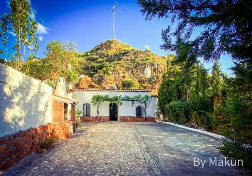 a white house with a mountain in the background at Cuevas Pedro Antonio de Alarcon in Guadix