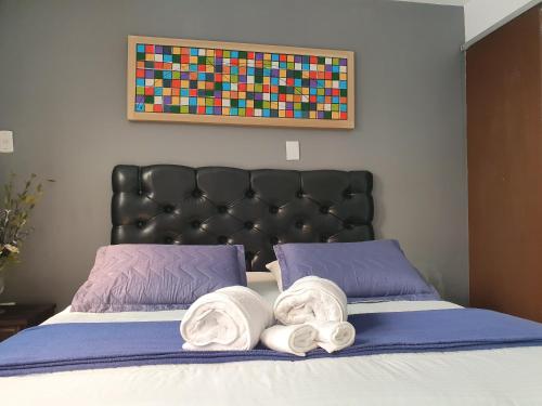 a bedroom with a bed with towels on it at Pousada Solar dos Cavaleiros Mendes in Macaé